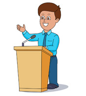A smiling man in a blue shirt and tie gestures while speaking at a wooden podium with a microphone.