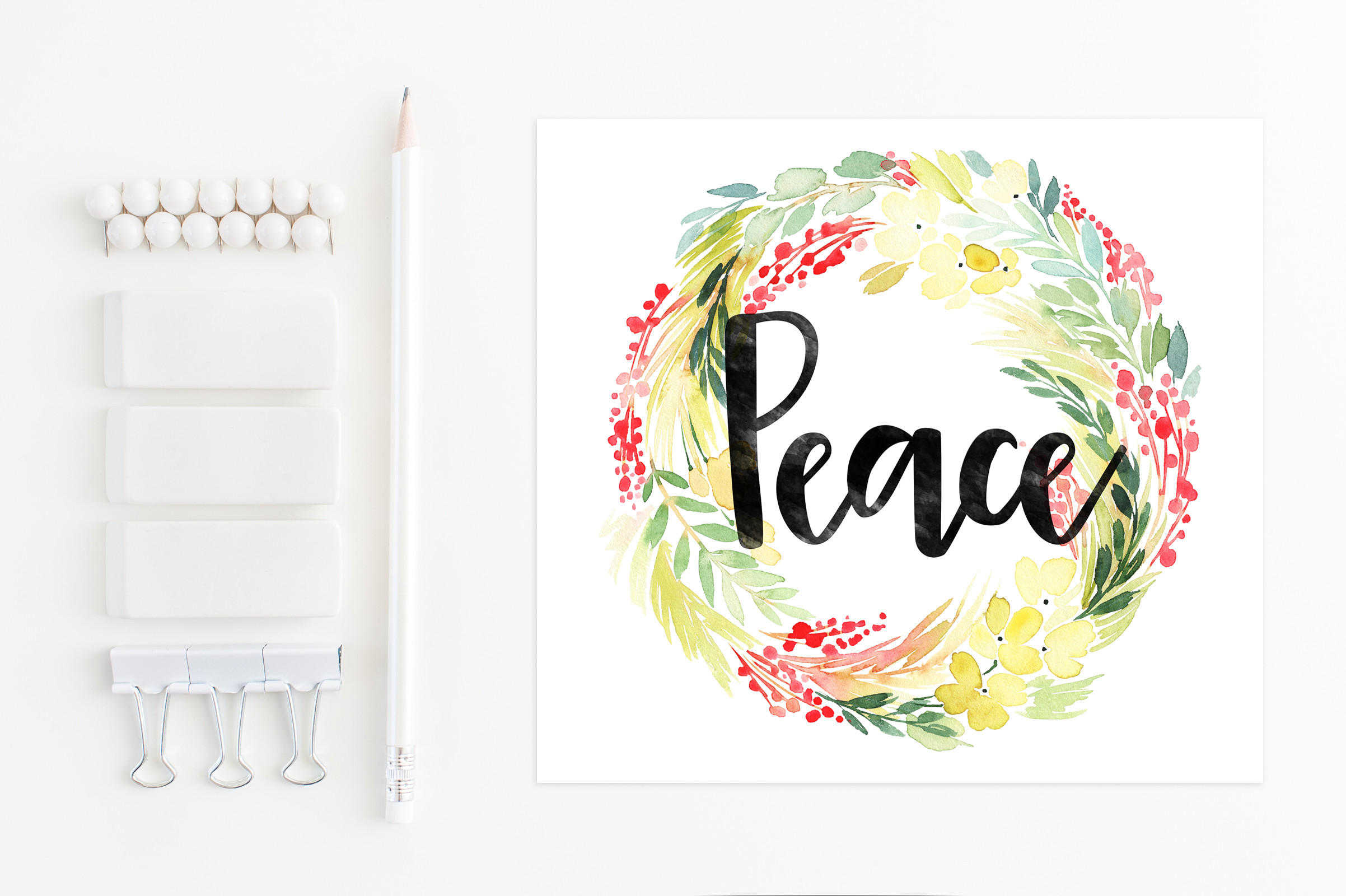 Watercolor floral wreath with "Peace" in black script, beside white stationery and pencil on white background.