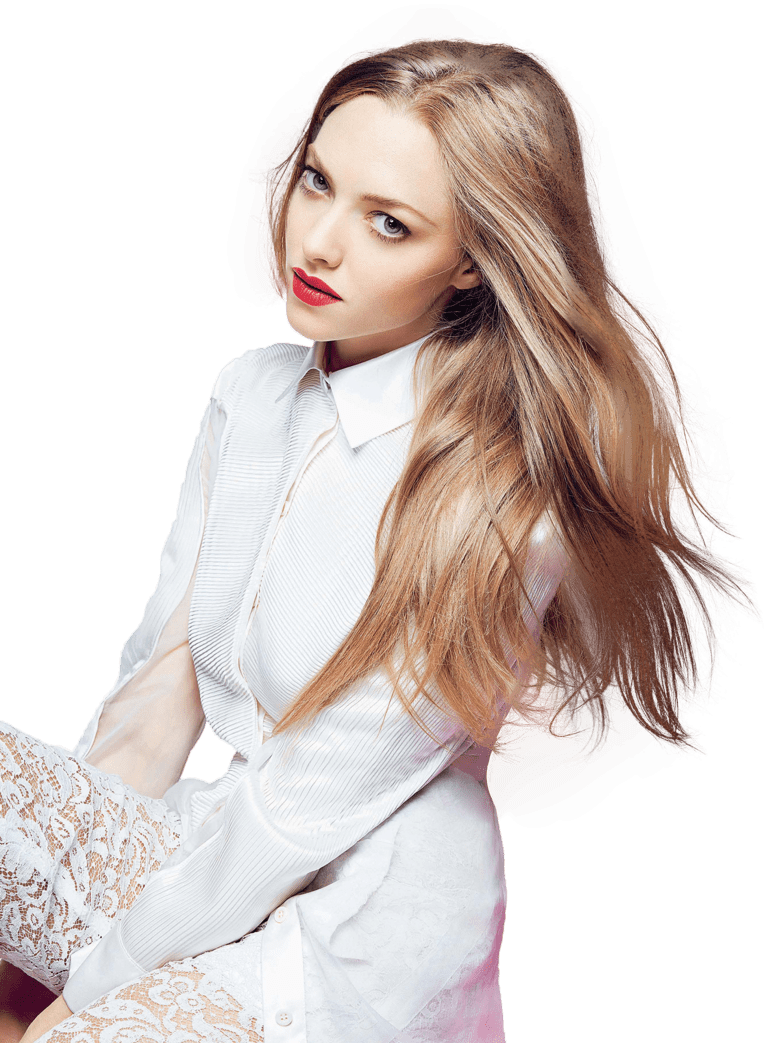 A woman with long blonde hair, bold red lipstick, wearing a white pleated blouse and lace skirt, posed against a green background.