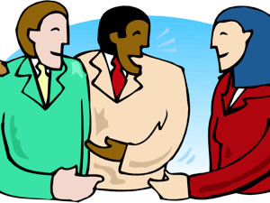 Three diverse professionals engaged in a friendly business discussion, smiling and gesturing collaboratively.