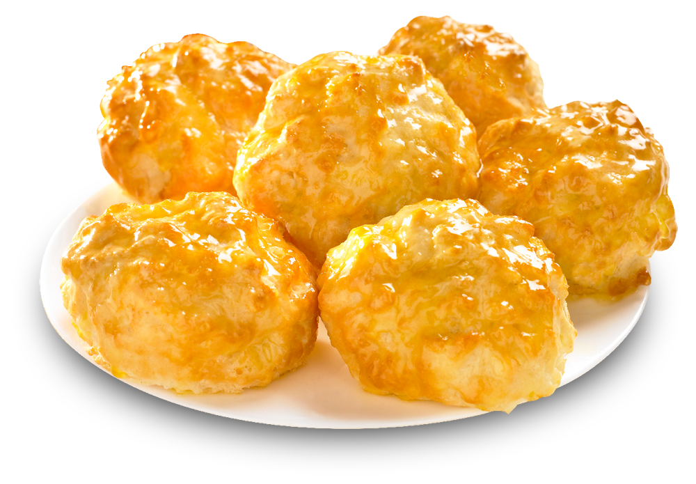 Golden, glossy cheese-topped biscuits piled on a white plate, freshly baked and appetizing.