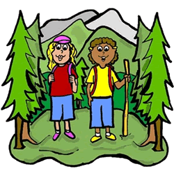 Two smiling children hiking in a forest with mountains in the background, carrying backpacks and a walking stick.