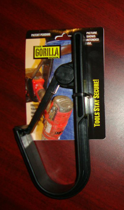 The Gorilla Hook tool holder in black plastic packaging, shown securing a red power tool with "Tools Stay Secure!" branding.