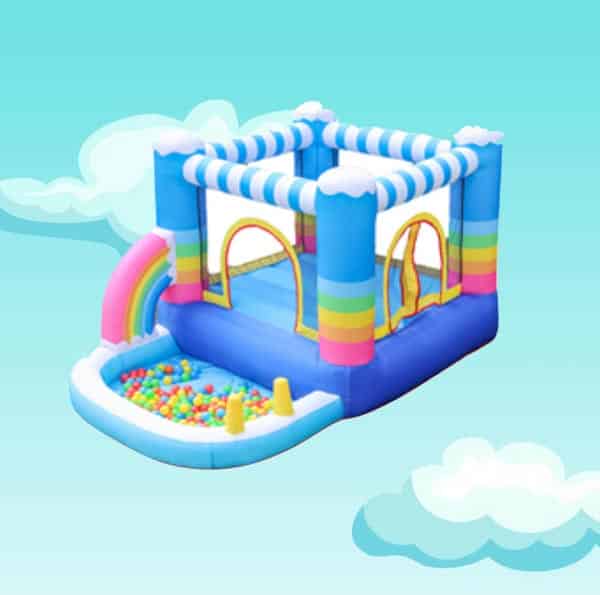 Colorful inflatable bounce house with rainbow arch, ball pit, and striped canopy against a sky-blue background.