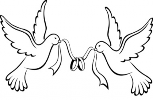 Two white doves in flight holding wedding rings with ribbons in their beaks, symbolizing love and marriage.