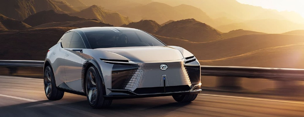 Lexus electric concept car speeding on a desert highway at golden hour with mountain backdrop.