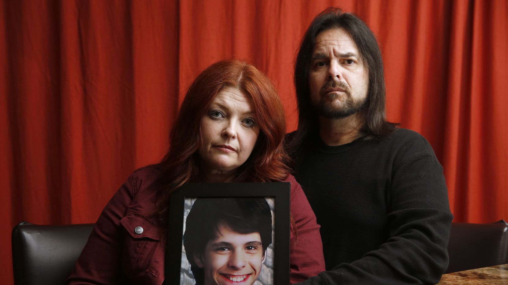 Parents Hold Photo of Deceased Son in Emotional Portrait