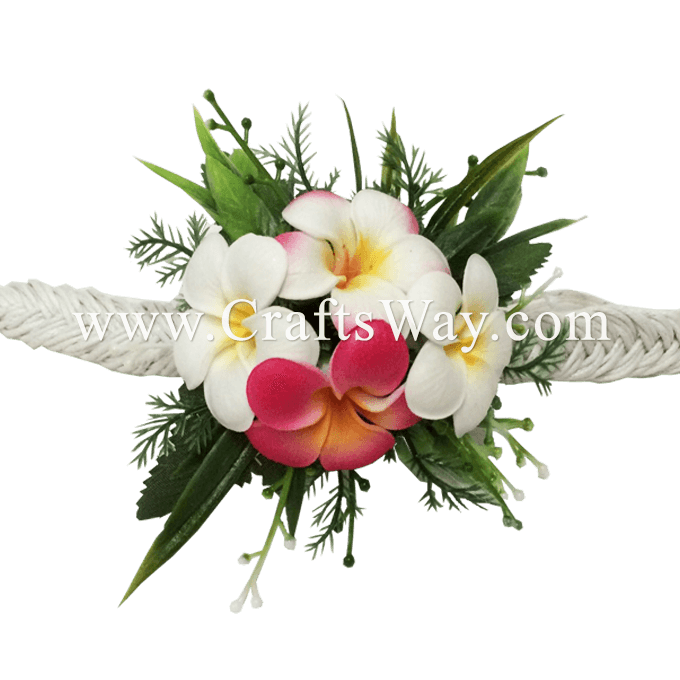 Tropical plumeria flower wrist corsage with greenery and white woven band, ideal for weddings or luaus.