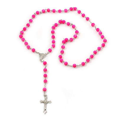 Bright pink Catholic rosary with silver crucifix and center medal on white background.