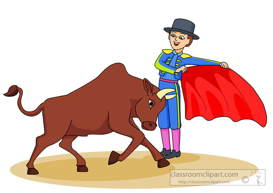 A smiling matador in traditional blue and yellow suit holds a red cape as a brown bull charges during a bullfight.