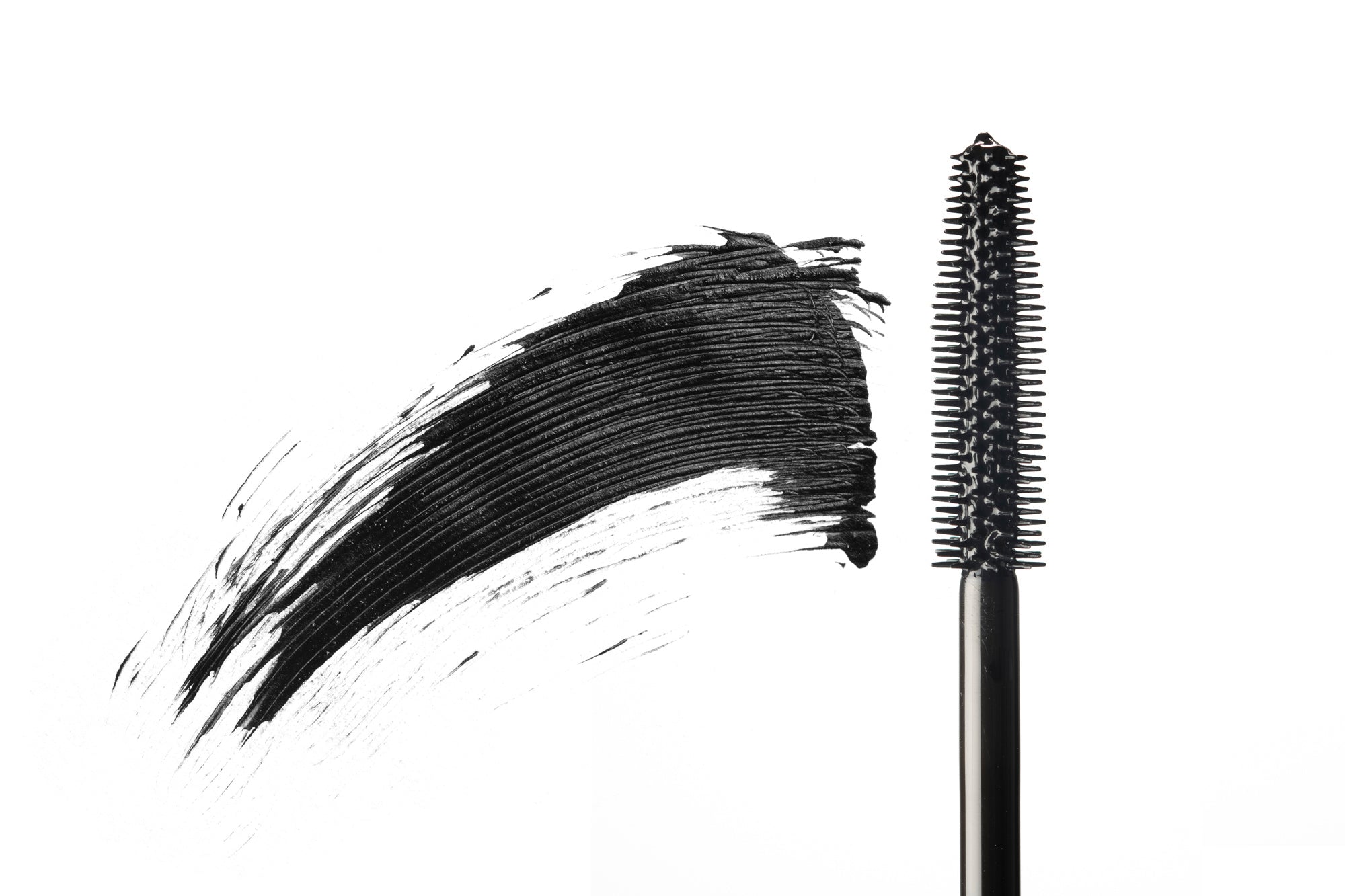 Black mascara wand with a bold, textured swipe of product on white background.