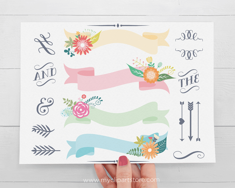 Hand holding a printable floral banner clipart sheet with decorative ribbons, flowers, and calligraphic elements.