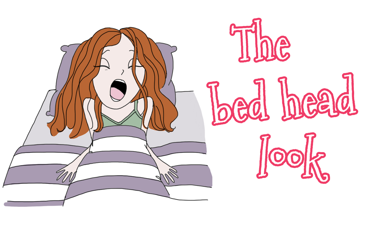 A cartoon woman with red hair yawning in bed under striped covers, labeled "The bed head look".