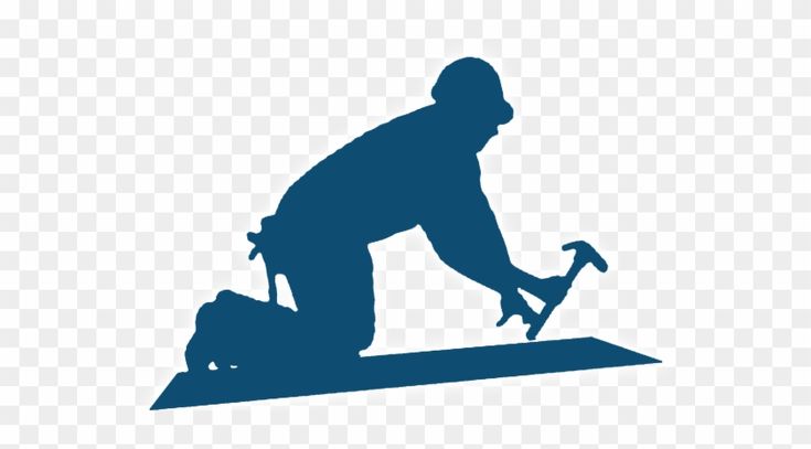Silhouette of a construction worker kneeling and hammering a nail into a plank, wearing a hard hat and tool belt.