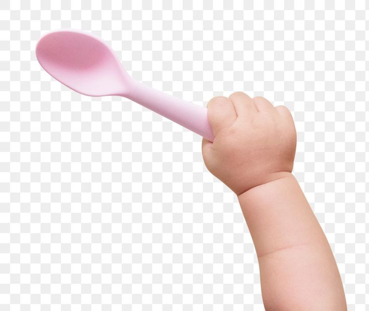 A baby's hand gripping a soft pink silicone spoon against a transparent background.
