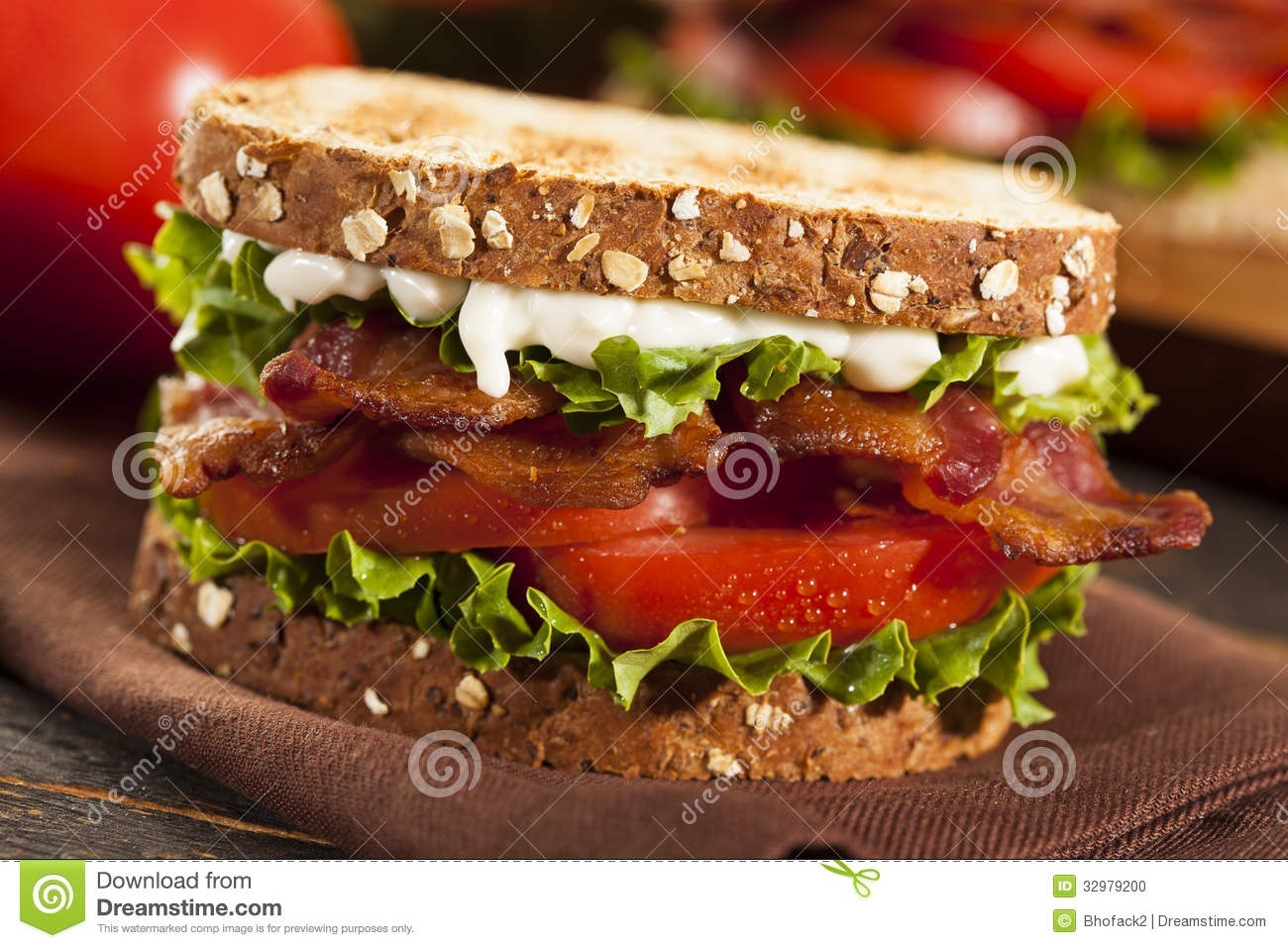 Classic BLT sandwich on whole grain bread with crispy bacon, fresh lettuce, tomato slices, and creamy mayo.
