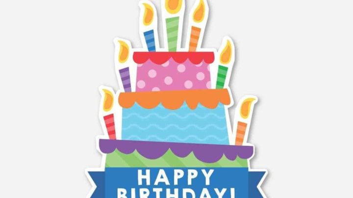 Colorful three-tier birthday cake with lit candles and "Happy Birthday!" banner.
