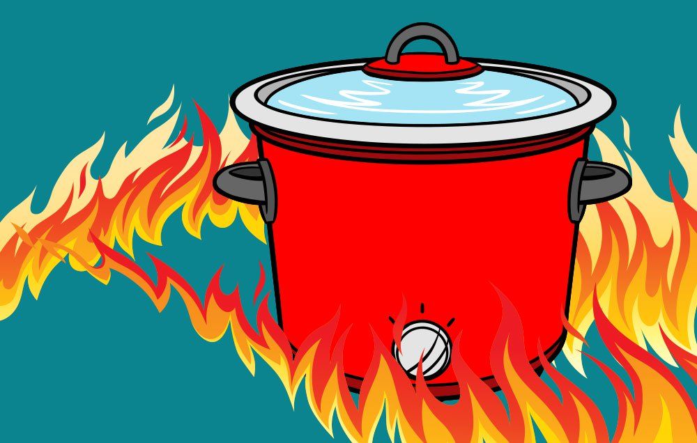 A red slow cooker engulfed in flames, lid on, with visible control knob and steam inside-illustrating a fire hazard.