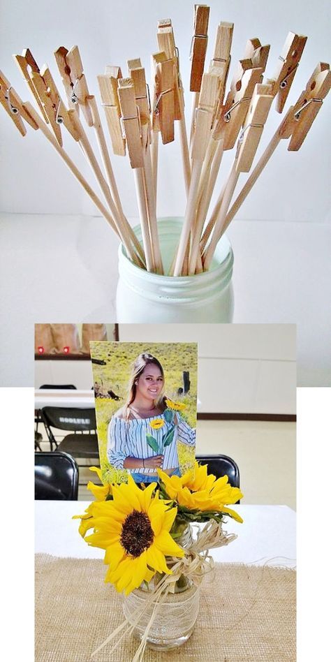 Mason jar centerpiece with wooden clothespins holding photos and sunflowers on burlap tablecloth.