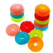 Brightly colored fruit-flavored hard candies stacked and scattered on white background.