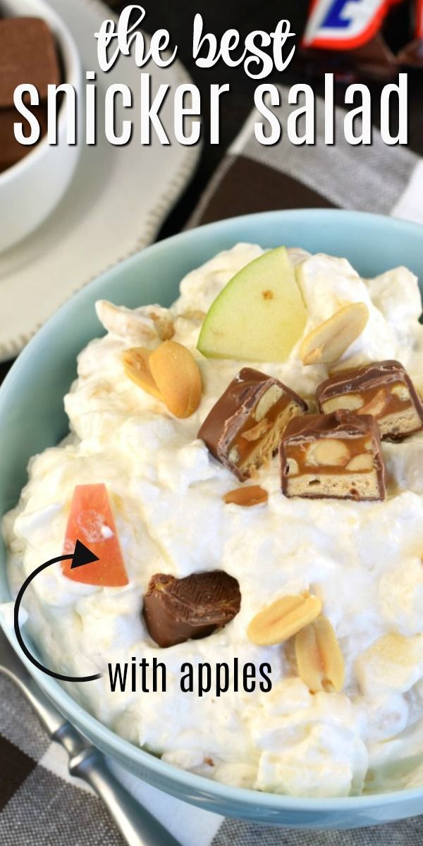 Creamy Snicker salad in a blue bowl with chopped apples, peanuts, and Snickers pieces.