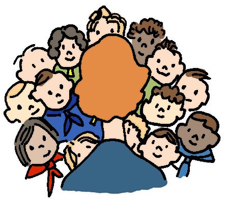 A teacher with orange hair sits facing a diverse group of smiling children in a circle, suggesting an inclusive classroom setting.