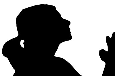 Silhouette of a woman in profile with hands raised in prayer or gratitude against white background.