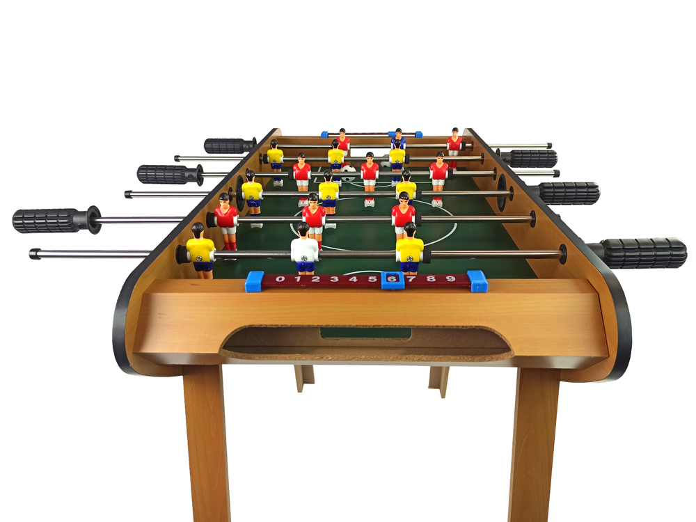 Wooden foosball table with red and yellow player figures, black handles, and numbered scoring track on a white background.