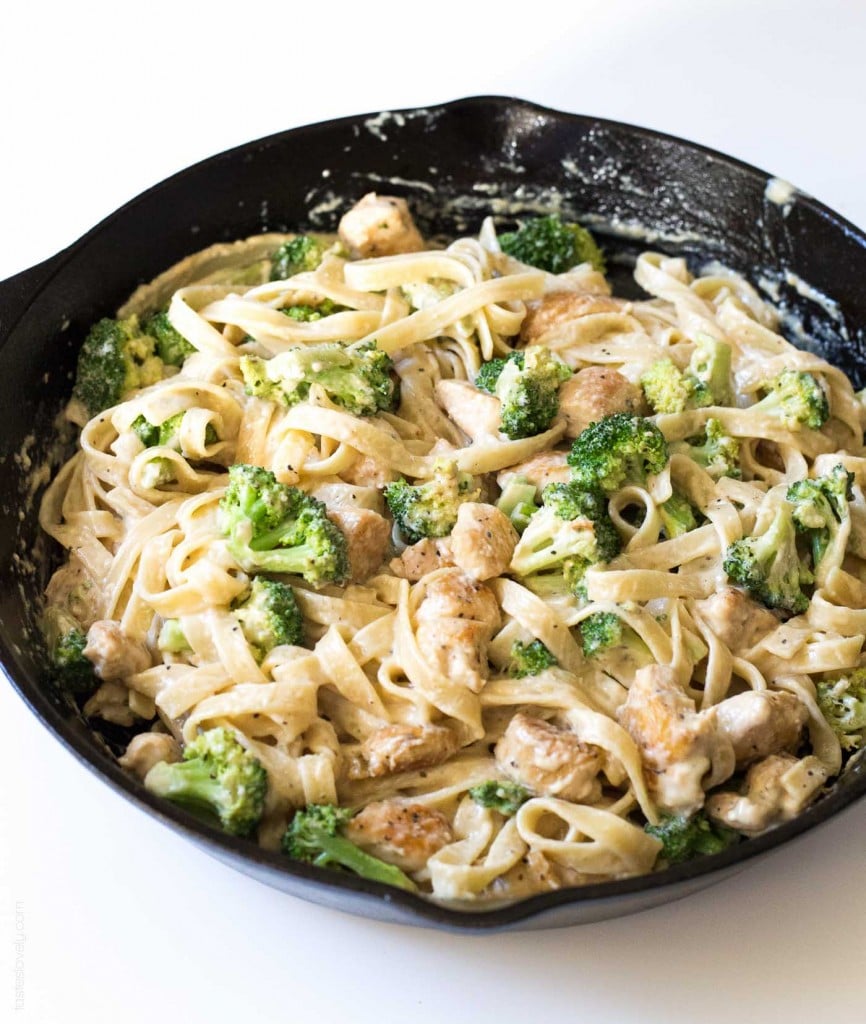 Creamy chicken and broccoli fettuccine in a black cast-iron skillet, garnished with black pepper.