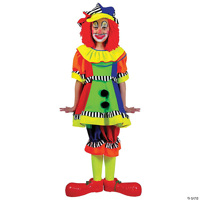 Child in colorful clown costume with red wig, striped hat, ruffled dress, and oversized red shoes.