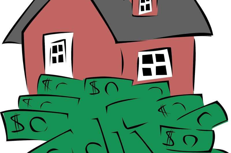 Red house partially buried in a pile of green dollar bills, symbolizing high housing costs or real estate investment.