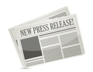 Stylized newspaper graphic with bold headline "NEW PRESS RELEASE!" and placeholder text columns.