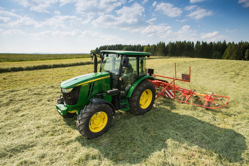 John Deere 5045E Tractor with Hay Rake in Field - Farm Equipment Showcase