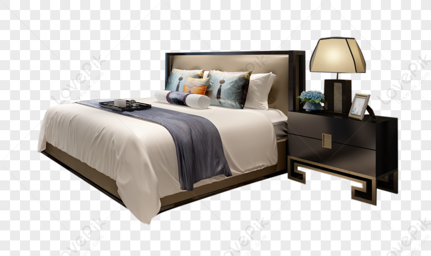 Modern bedroom setup with upholstered bed, decorative pillows, dark wood nightstand, table lamp, and floral accent.