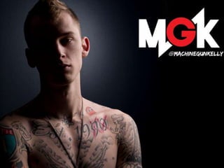 Shirtless tattooed man with intense gaze, MGK logo in top right corner on dark background.