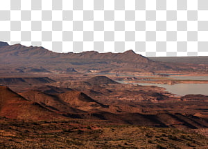 Arid desert landscape with layered red rock formations, distant mountains, and a reservoir under a hazy sky.