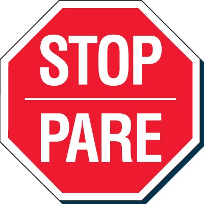 Bilingual stop sign with "STOP" in English and "PARE" in Spanish on a red octagonal background.