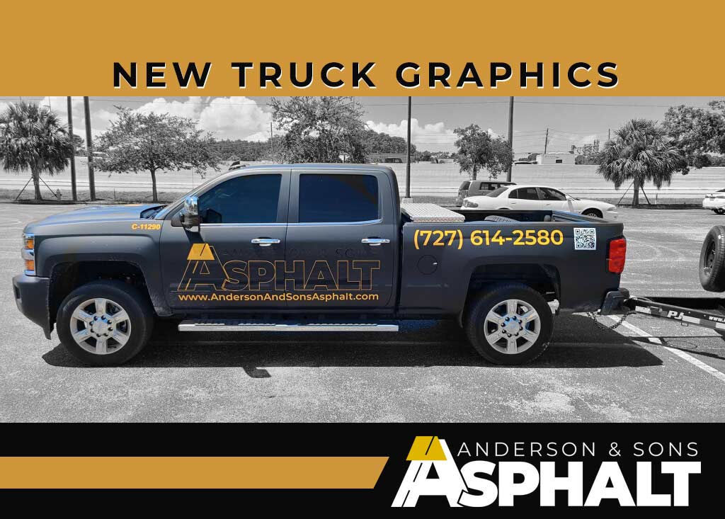 Black pickup truck with new yellow and white "Anderson & Sons Asphalt" graphics, parked in lot with trailer attached.