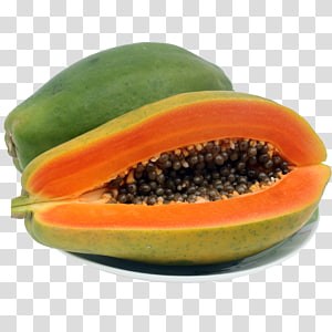 A ripe papaya cut in half, revealing orange flesh and black seeds, beside a whole green papaya on a white plate.