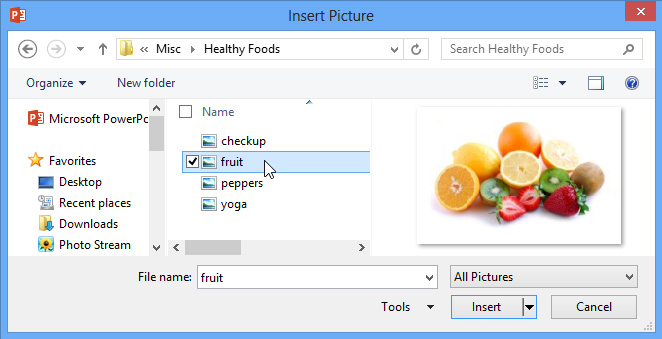 A colorful assortment of fresh fruits including oranges, kiwis, strawberries, and lemons displayed in a PowerPoint "Insert Picture" dialog.
