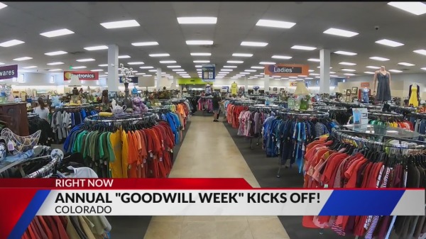Interior of a bustling Goodwill store during Annual Goodwill Week in Colorado, with colorful clothing racks and signage.