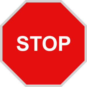 Red octagonal stop sign with bold white "STOP" text, standard traffic control symbol.