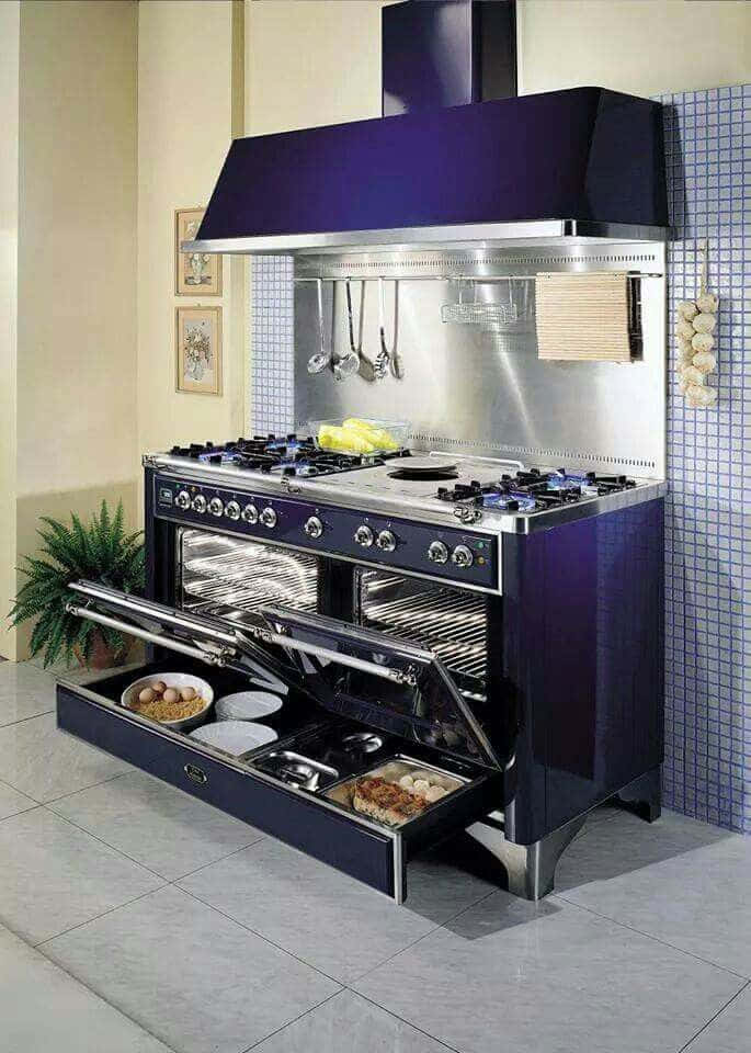 Luxurious purple and stainless steel professional-grade kitchen range with dual ovens, gas cooktop, and pull-out storage drawer.
