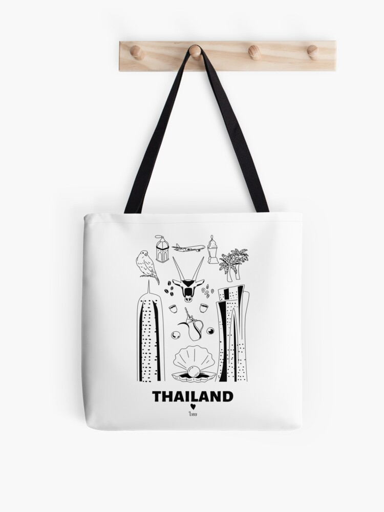 White tote bag with black line-art illustrations of Thai icons including temples, elephant, bird, palm tree, and "THAILAND" text.