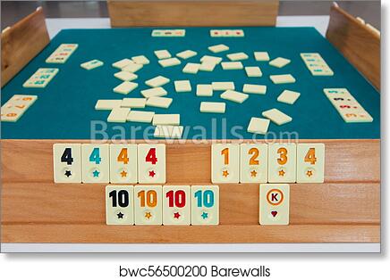 Rummikub game in progress on a green felt table with numbered tiles and jokers arranged on wooden racks.