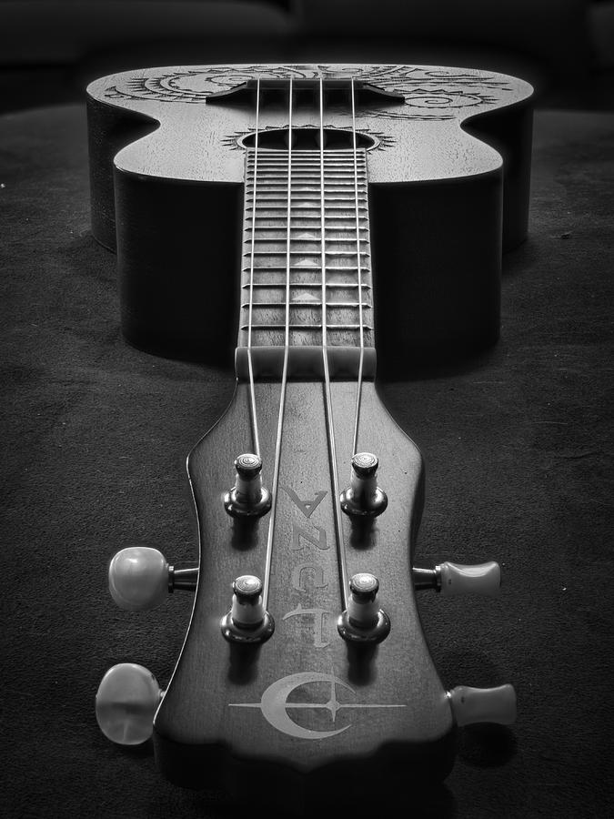 Black-and-white close-up of a handcrafted Aztec-branded ukulele with intricate fretboard and headstock design.
