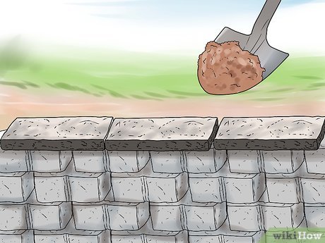 A trowel applying mortar onto a stone wall during masonry construction.