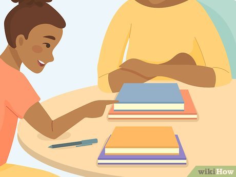 Two students studying together at a table with stacked books and a pen.