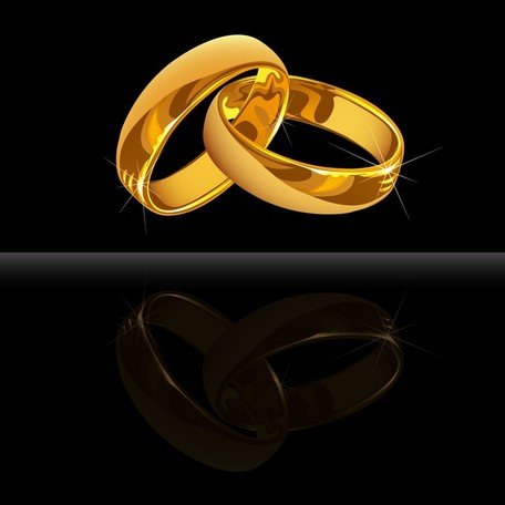 Two interlocked golden wedding rings with reflective surface and sparkle highlights on black background.