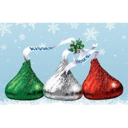Three Hershey's Kisses in green, silver, and red foil with festive ribbons and mistletoe against a snowy blue background.
